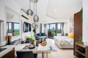 Il comprend une cuisine et un salon avec un lit et une table. dans l'établissement Dominiks Stylish Resort Gem Ocean View Pool Queen Bed at Tambuli 8 Floor Fast Wifi, à Maribago 55 autres photos