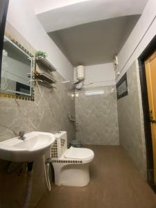 a bathroom with a toilet and a sink at Haven Stay in Dibrugarh