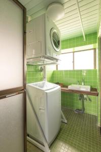 a green tiled kitchen with a sink and a microwave at 一棟貸しハウスまれち in Kumejima +8 photos