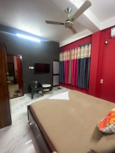 a bedroom with a bed and a red wall at Haven Stay in Dibrugarh