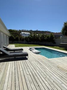 a wooden deck with a swimming pool on a house at 1 Diadem in Plettenberg Bay