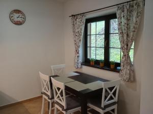 a dining room with a table and chairs and a window at Apartmán Viktória 5 in Ružomberok