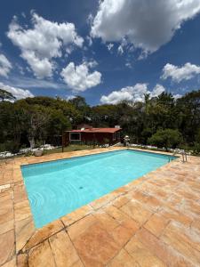 a swimming pool in front of a house at Casa de campo em São Roque - Sítio Beija Flor in São Roque