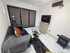 a living room with a couch and a television at Heaven in Sutton