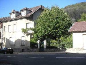 une maison blanche avec un arbre en face d'une rue dans l'établissement Apartment Coecilia, à Ax-les-Thermes