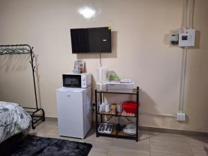 a room with a white refrigerator and a microwave at Cosy Beds Web in eMalahleni