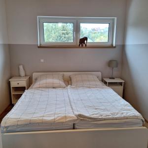 a bedroom with a bed and a horse statue in a window at Ferienwohnung Hügelhaus Fürstenberg in Bad Wünnenberg