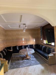 ein Wohnzimmer mit Sofa und Tisch in der Unterkunft Maison familiale 2 chambres salon marocain in Tiznit