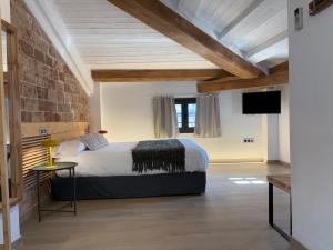 a bedroom with a large bed and a brick wall at ROS CENTRIC Cal Ros in Montblanc