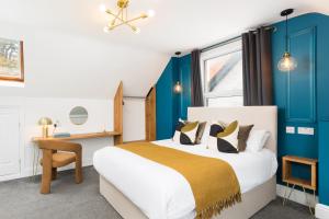 a bedroom with a bed and a desk and a window at The Adelphi Aparthotel in Stratford-upon-Avon