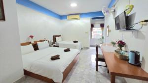 a room with a bed and a dining room with a table at You And Me Guesthouse in Cha Am