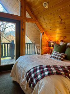 a bedroom with a bed in a wooden cabin at Little Pine Lodge a Smokies Hideaway - 1 mi to GSMNP - King Suite & Loft, Fireplace, Hot Tub & BEARS! in Sevierville