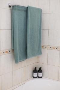 a bathroom with two green towels and a bath tub at Mediterranean Dream by the Sea in Paphos City