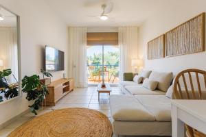 a living room with a couch and a tv at Mediterranean Dream by the Sea in Paphos City