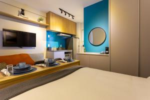 a bedroom with a bed and a table with plates on it at Apê Blue Frei Caneca Premium Rooftop Jacuzzi Academia in Sao Paulo