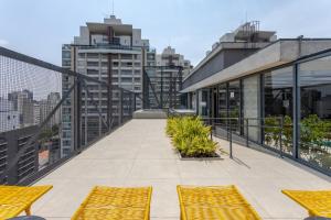 a balcony with yellow chairs on top of a building at Apê Blue Frei Caneca Premium Rooftop Jacuzzi Academia in Sao Paulo +14 photos