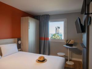 a room with a bed with a hat on it at ibis budget Nice Aeroport in Nice