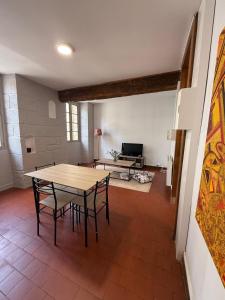 una sala de estar con una mesa, sillas y un sofá en Sous les Toits de Boussac, en Boussac