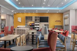 a restaurant with tables and chairs and a bar at Home2 Suites By Hilton Woodstock On in Woodstock