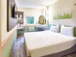 アグノーにあるibis budget Haguenau Strasbourg Nordの大きなベッドとバスルームが備わるホテルルームです。