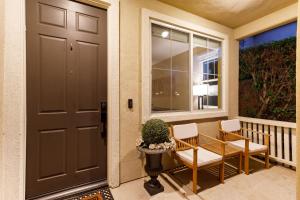 Desert Groves Mobile Home ParkにあるWalk to the Festivals - Private Pool & Spaのドアと椅子2脚と植物のあるポーチ