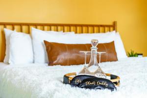a tray with a wine glass on top of a bed at Short North Convention King Bed Free Parking! in Columbus
