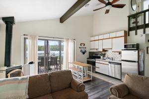 ゲイロードにあるQuiet and Cozy Lakefront Home Near Mt Boyneのソファとキッチンのあるリビングルーム
