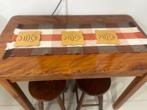 ein Holztisch mit drei gelben Servietten darauf in der Unterkunft Praia Ubatuba Apartamento SilBraSil in Ubatuba