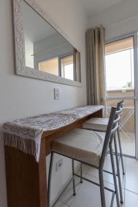 einen Spiegel und einen Tisch und einen Stuhl in einem Zimmer in der Unterkunft Praia Ubatuba Apartamento SilBraSil in Ubatuba
