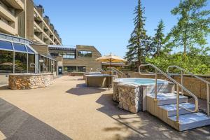 a patio with a hot tub and stairs in a building at Beaver Run Studio With Kitchen, Dog Friendly- 4217 in Breckenridge