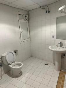 a bathroom with a toilet and a sink at فندق لؤلؤة الجوار مكه in Makkah