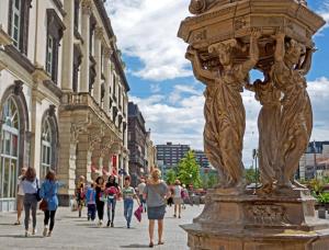people walking down a street next to a statue at Hôtel Saint André Gare SNCF in Clermont-Ferrand