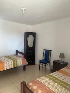 a bedroom with two beds and a dresser and a chair at Hab baño compartido, 10 cdas Plaza de Armas, con terraza y vista a los volcanes in Arequipa