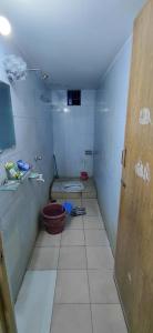 een kleine badkamer met een toilet en een deur bij Faria House in Dhaka