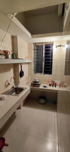 een kleine keuken met een wastafel en een raam bij Faria House in Dhaka