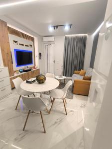a white living room with a table and chairs at Alex Home Patras in Patra