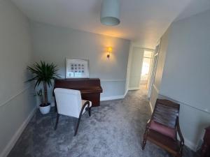 a living room with a piano and a chair at Holywood Hideaway 2 bedroom retreat in Cultra