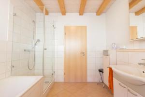 un baño con ducha y lavabo en Haus Sattelgrund, en Münstertal 19 fotos más