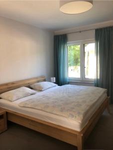 a bedroom with a large bed and a window at Ferienwohnung Waldesruh mit Kaminofen und Balkon in Seilershof