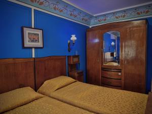 a bedroom with two beds and a blue wall at Family Hotel at Renaissance Square in Plovdiv