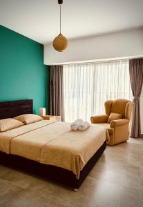 a bedroom with a large bed and a chair at THE PALMiA I iskele I Trikomo in Aglantzia +31 photos