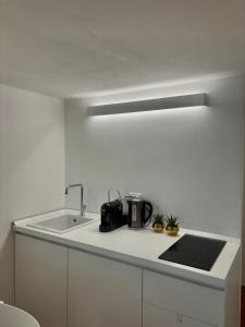 una cucina bianca con lavello e fornello di Sea Breeze a Riomaggiore