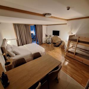 a hotel room with a bed and a table at Apartman 452 sa pogledom na stazu Hotel Vučko private host in Jahorina