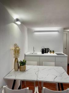 una cucina con tavolo in marmo e mobili bianchi di Sea Breeze a Riomaggiore Altre 36 foto