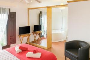 MontsonisにあるHabitaciones con encanto - Cal Alejandroのベッドルーム1室(ベッド1台、椅子、バスタブ付)