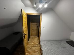 ルドビコビツェ・クウォツキエにあるNest Hausのベッドルームにつながるドア付きの屋根裏部屋