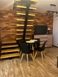 ルドビコビツェ・クウォツキエにあるNest Hausのテーブルと椅子とテレビのあるダイニングルーム