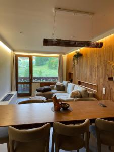 una sala de estar con una mesa y un sofá en Appart 60 M2 pied pistes terrasse Vars les Claux, en Vars