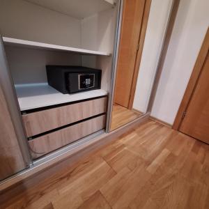 a small microwave sitting on a shelf in a room at Apartman 452 sa pogledom na stazu Hotel Vučko private host in Jahorina