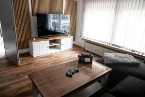 a living room with a television and a coffee table at Ferienhaus Lotte in Vöhl